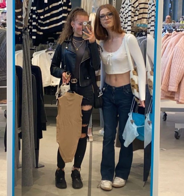 Brianna Ghey and Daisy stood together in a mirror. They are in a Primark and both are holding items they have selected.