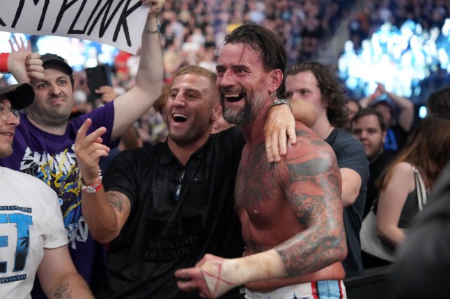 BERLIN, GERMANY - AUGUST 31: UFC Fight Oban Elliott greets CM Punk after Punk defeated Drew McIntyre (not pictured) in a strap match during the WWE Bash in Berlin Premium Live Event at Uber Arena on August 31, 2024 in Berlin, Germany. (Photo by WWE/Getty Images)