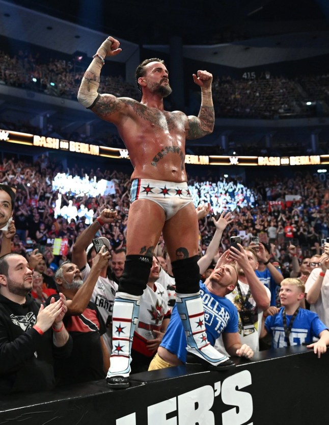 BERLIN, GERMANY - AUGUST 31: CM Punk celebrates his victory over Drew McIntyre (not pictured) with fans following their strap match at the WWE Bash in Berlin Premium Live Event at Uber Arena on August 31, 2024 in Berlin, Germany. (Photo by WWE/Getty Images)