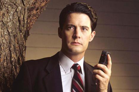 Kyle MacLachlan as Agent Dale Cooper wearing a suit and holding a dictaphone in Twin Peaks