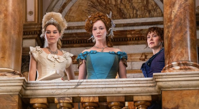 Imogen Waterhouse, Christina Hendricks and Simone Kirby in The Buccaneers stood on a balcony