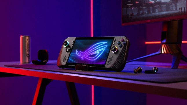Asus ROG Ally X handheld sat on a desk under red and blue lighting