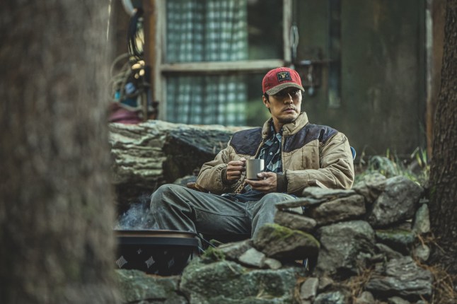 So Ji-Sub as Nam Gi-jun in Mercy for None in a jacket and aht sat outside